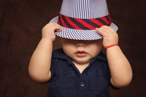 bebe garcon avec chapeau raye et chemisette bleue