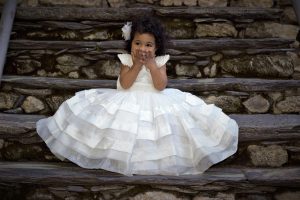 petite fille robe blanche assise sur escaliers