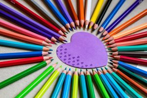 feuille forme coeur entouree crayons de couleur