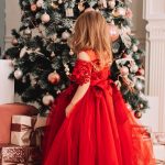 fillette robe soiree rouge devant sapin